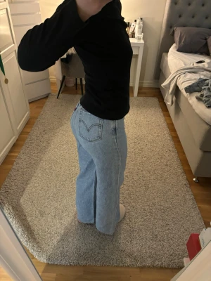 Ljusblå raka jeans från Levi's - Säljer ett par ljusblå jeans från Levi's med rak passform och hög midja. Klassisk femficksmodell och Levi's ikoniska bakficka med V-söm. W26 har sytt upp byxorna och dom passar mig som är 1.63 med korta ben🌺Nypris runt 1300kr