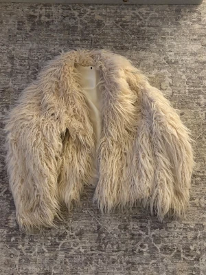 Beige fluffig fuskpälsjacka - Säljer en supermjuk och fluffig beige fuskpälsjacka. Otroligt mysig och perfekt nu till vintern men även i vår! Finns ingen storlekslapp men skulle uppskatta att det är en S/M😇