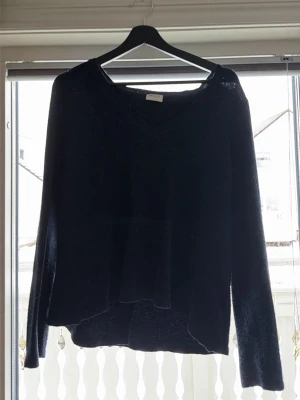 Mörkblå stickad tröja med V-ringning - Den är ”korasande” och i gott skick 