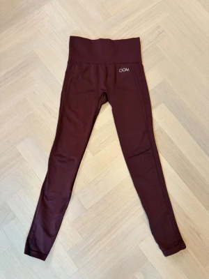 Vinröda leggings från Drop of Mindfulness - Snygga vinröda leggings från Drop of Mindfulness med hög midja och tight passform. Tillverkade i stretchigt funktionsmaterial som passar perfekt till träning. Diskret logga framtill och text bak i midjan.
