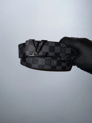 Schackrutig bälte  - Schackrutig-mönster bälte, size 105 cm. Helt nya aldrig använda pris kan diskuteras skriv vid behov av frågor