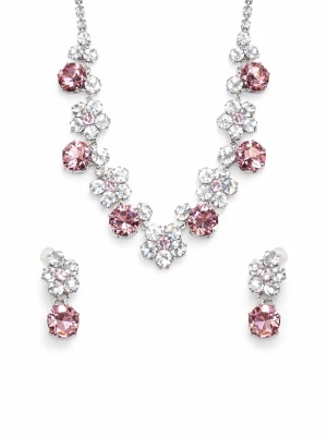 Set med rosa och vita smycken - Säljer ett glittrande smyckeset med halsband och örhängen. Setet har stora rosa stenar och mindre vita kristaller i blommönster. Perfekt för att lyfta din outfit med extra bling. Metall i silverfärg och gnistrande detaljer.