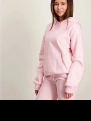 Ljusrosa hoodie  - Mysig ljusrosa hoodie med huva och känguruficka. Modellen är loose fit med långa ärmar och ribbade muddar. Perfekt för en avslappnad stil. Tillverkad i mjuk bomullsmix för extra komfort. Storlek 158/164