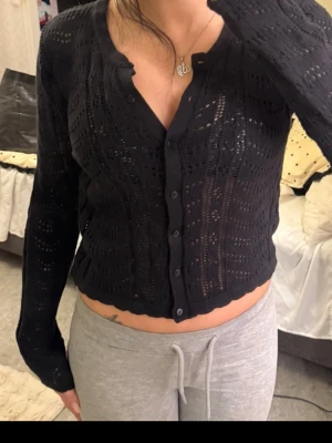 Svart virkad kofta med knappar - Snygg svart virkad kofta med långa ärmar och knappar framtill. 