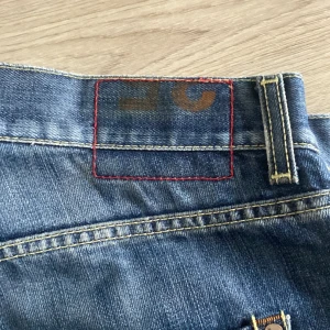Blå jeans från Dondup - Snygga blå jeans från Dondup med klassisk femficksdesign och kontrastsömmar. Jeansen har en normal passform och raka ben, tillverkade i slitstarkt bomullsjeans. Perfekta för dig som gillar en stilren och tidlös look.