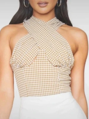 Rutig omlottopp från PrettyLittleThing - Snygg beige/gul och vit rutig omlottopp från PrettyLittleThing med korsad halterneck och tight passform. Toppen är ärmlös och har en trendig, croppad design som passar perfekt till höga byxor eller kjol.