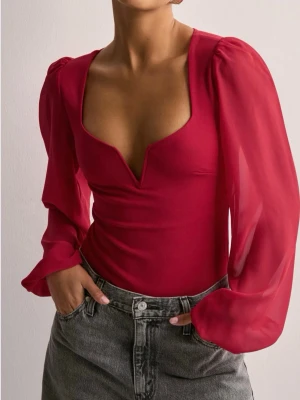 Röd djup v-ringad body - Trendig röd body med djup v-ringning och långa puffärmar i mesh. Kroppsnära passform och transparenta ärmar ger en snygg kontrast till den släta kroppen. Perfekt för dig som vill sticka ut med en statement-piece. Endast använd en gång och funkar jätte bra att ha bh på sig under utan att det syns!💞