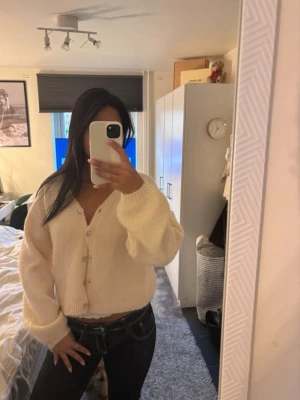 Stickad kofta från gina tricot  - Mysig krämvit stickad kofta med v-ringning och pärlemorknappar. Helt ny där av priset. 