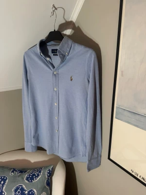 Ljusblå Ralph Lauren skjorta - En riktigt fräsch och stilig Ralph Lauren skjorta             Skick: 9/10 iprincip helt ny.                              Storlek: M                                                                 Har du några frågor eller prisförslag är det bara att höra av sig