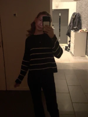 Svart stickad tröja med ränder Kappahl - Svart stickad tröja från Kappahl med vita horisontella ränder. Tröjan har en avslappnad passform och långa ärmar. Perfekt för en stilren och enkel look. Säljer på grund av att den inte passar. Jätteskön och enkel att ha till ett par kostymbyxor!❣️