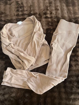 Tränings kläder  - Ett sett från new yorker, nästan aldrig använd , lilabeige färg och mellanlåga byxor till. Tröjan e lite urringad 