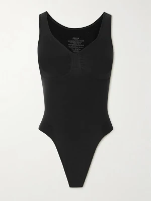 Svart shaping-body från Skims - Snygg svart shaping-body från Skims med breda axelband och djup ringning. Tillverkad i ett stretchigt och mjukt material som formar kroppen. Sömlös design med rynkdetalj vid bysten för extra passform. Perfekt under tighta plagg.