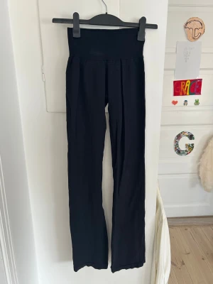 Svarta ribbade utsvänga leggings (yoga pants) - Säljer ett par svarta ribbade leggings från Stadium med hög midja och utsvängda ben. Stretchigt material som sitter skönt och följer kroppen. Perfekta till en avslappnad och trendig look. Är i storlek XS/S. Lite noppror förekommer