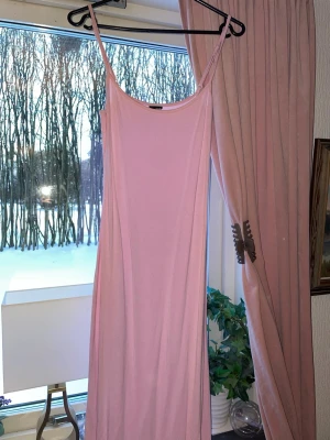 Ljusrosa lång klänning från Gina - En enkel och stilren ljusrosa klänning med smala axelband och bra passform. Den är i storlek S från Gina! En sååå skön klänning att ha på sig och den passar verkligen till allt💕