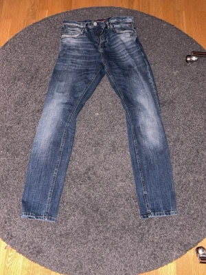 Blå relaxed fit jeans - Säljer ett par blå slim fit jeans medtvättade detaljer. Jeansen har femficksdesign, normal midja och luftiga ben. Perfekta för en avslappnad stil. Jeansen är från No Exess och materialet är denim med strech.