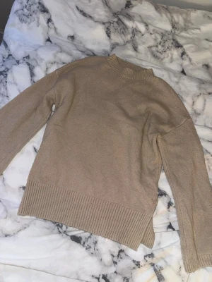 Beige stickad tröja med ribbade detaljer - En snygg och mysig stickad tröja. Lite nopprig 
