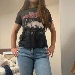 Svart kortärmad t-shirt från Gina tricot  - Säljer en svart t-shirt från Gina med tryck framtill i rött och vitt. T-shirten är kortärmad, har en normal passform och är gjord i mjuk bomull. Perfekt till jeans eller shorts för en avslappnad look.