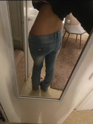 Low waist bootcut ljusblåa jeans - Säljer ett par ljusblå jeans med låg midja. Sydde in de lite då de va lite stora. De va i stl M men nu passar de mer S/M. Sprättade upp den längst ner så att de skulle vara lite längre, nu är innerbenslängen 87cm. För referens är jag 169cm lång. Köptes för 900kr!