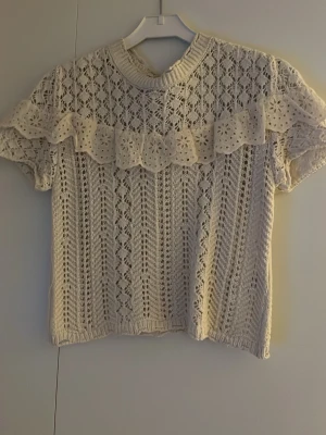 Vit spetsstickad topp från Nisan - Säljer en supersöt vit stickad topp från Nisan som passar storlek XS. Helt oanvänd 