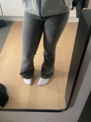 Gråa bootcut jeans mid waist - Säljer dessa jeans som jag har använt ca 3 gånger, har bara luggit i garderoben så dem är ganska nya. Midjan=62cm, Innebenslämgd=74cm, lårvidd=38cm, fotvidd=48cm