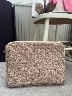 blommigt datorfodral - Sötaste datorfodralet. Får plats med mycket dator böcker osv, har ett litet fack inuti för mindre saker som air pods oså