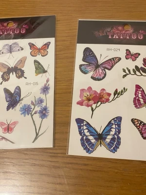 Färgglada fjäril-tatueringar cosplay - Två ark med temporära tatueringar med fjärilar och blommor i olika färger som blått, lila, rosa och orange. Perfekta som accessoar till maskerad eller cosplay. Motiven är detaljerade och livfulla,  finns fler kvar i olika mönster 