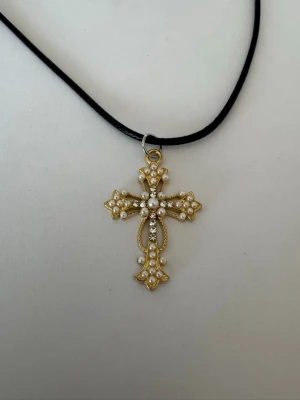 Svart halsband Guldigt kors vita pärlor - Halsband som inte är i äkta silver/guld. Kedja är oftast 50cm men kan ibland komma i 45cm. Kedja är rostfritt stål, berlock oftast i zinklegering men kan även det i vissa fall vara rostfritt stål. Be gärna om mått på berlock om detta är viktigt då bilderna är missvisande när det gäller hur stora dom är! 🌹❤️  Allt är nytt.  Bud accepteras inte 🥰🌹