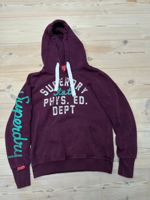Superdry hoodie  - Säljer denna Superdy hoodie, den är i väldigt fint skick och den har en riktigt snygg sliten look på sig som är väldigt eftertraktad. Den är i storlek M men passar också S  Hör av er vid minsta lilla fråga! Pris ej hugget i sten! Kolla min profil för mer liknande plagg! 😊