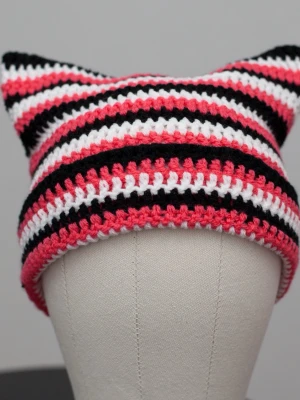 Crochet cat beanie virkad kattmössa korall svart vit randig  - Helt ny virkad mössa med kattöron. Onesize, passar upp till ca 59cm. Virkad i mjukt akrylgarn. Den är mer korallfärgad än rosa. Färger kan variera beroende på skärminställningar.