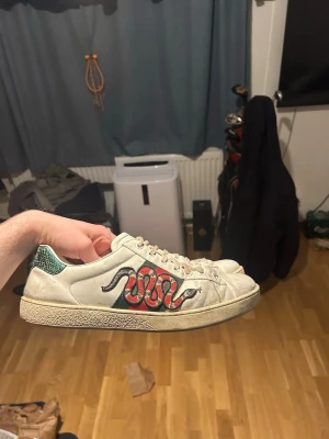 Gucci skor - Säljer ett par vita Gucci Ace sneakers i okej bra skick med en tvätt så blir det fräscha igen. Pris kan diskuteras, skriv om ni undrar över något! 