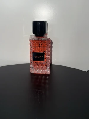 Admiration Eternal parfym rosa glas - Parfymflaska från Admiration med namnet Eternal. Flaskan är fyrkantig och har ett mönstrat, nästan kristalliknande glas i rosa ton. Korken är svart och har en kantig, modern design. Perfekt för dig som gillar snygga detaljer på parfymhyllan.