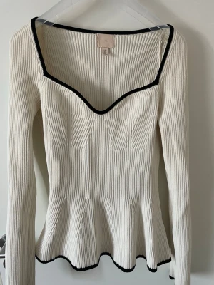 Vit ribbad topp - Vit ribbad topp från H&M med långa ärmar och svart i kanterna!