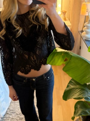 Svart spetsblus med volangdetaljer - Säljer en svart croppad spetsblus med långa ärmar och snygga volangdetaljer💕