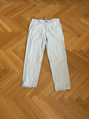 Ljusbeigea linnebyxor  - Säljer ett par ljusbeigea linnebyxor med avslappnad passform och dragsko i midjan.🔥 Knappt använda, st M, med vänster ben nere lite slitna. Perfekta för en chill och stilren look under varma dagar.