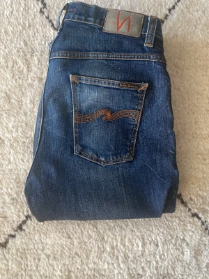 Nudie Jeans  - Ett par galna Nudie Jeans med riktigt cool tvätt. Grymt bra skick, dock ett liten hål, se bild 3. Hålet märks inte av vid användning men vid behov kan du lämna in dom hos Nudie så lagar dom utan beskostnad. Storlek 30/32, passar även 31/32. Slim-straight passform. Modell: Dude Dan