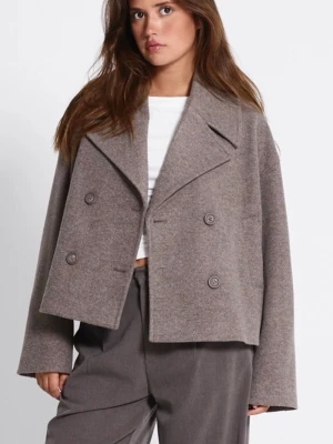 Kort grå kavaj med dubbelknäppning - Snygg kort kavaj i grått med breda slag och dubbelknäppning framtill. Kavajen har en boxig passform och är tillverkad i ett mjukt material som ger en avslappnad look. Perfekt att matcha med både jeans och dressade byxor.beuge brun förg 