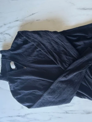 Svart merinoullströja These Glory Days - Snygg svart/mörkblå stickad tröja från These Glory Days i mjuk och exklusiv merinoull. Tröjan har halv dragkedja vid halsen och enkel, stilren design som passar perfekt till lager på lager. Skandinavisk design med fokus på kvalitet.