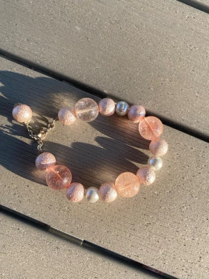 Rosa pärlarmband med glittriga kulor - Säljer ett snyggt egentillverkat armband med stora rosa glittriga pärlor, silverfärgade pärlor och transparenta rosa pärlor. Armbandet har ett metallspänne. Ca 19 cm långt. 