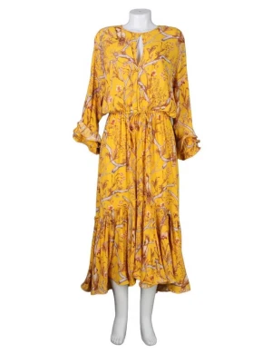Gul blommig långklänning - Gul långklänning med blommigt mönster och volangdetaljer. Klänningen har lång ärm med volang vid ärmslut, knyt i midjan och rund halsringning med liten öppning framtill. Tillverkad i ett lätt och luftigt material.