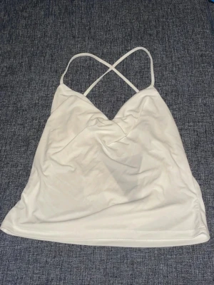 Vit linnetopp  - Säljer en vit linnetopp med korsade axelband i ryggen. Den blir lite V-ringad när du har på dig den och ryggen är ganska öppen. Toppen är inte helt klar vit utan lite åt det krämiga hållet. Perfekt att matcha med jeans eller kjol för en fräsch eller festlig look. Lappen är tyvärr inte kvar och minns inte vart jag köpte den exakt men det är antingen från Zara eller Mango 🤍