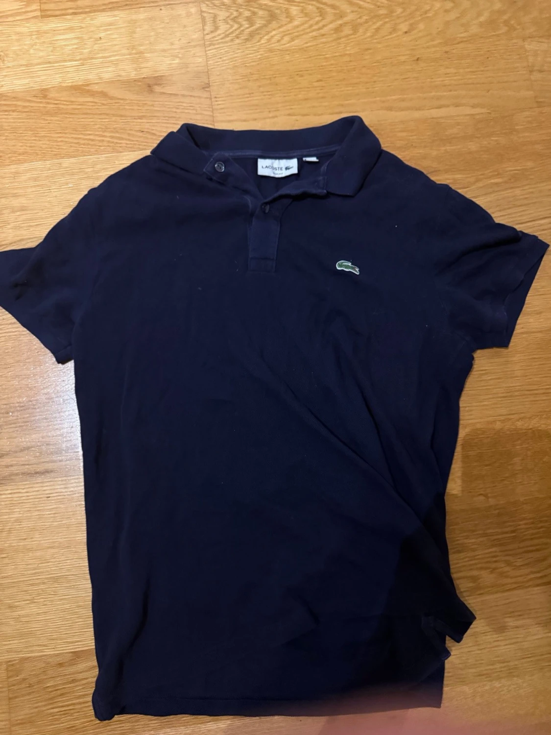 Mörkblå pikétröja från Lacoste