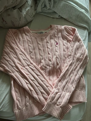 Polo tröja - Supersöt ljusrosa kabelstickad tröja med rund halsringning och ribbade muddar. Nypris: 1140.