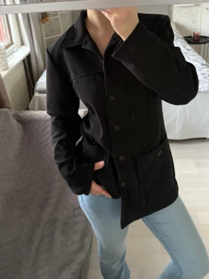 Svart kavaj från Jennifer collection - Mycket fin kavaj med ribbat material, i storlek 42. Hör gärna av dig om du har någon fråga!