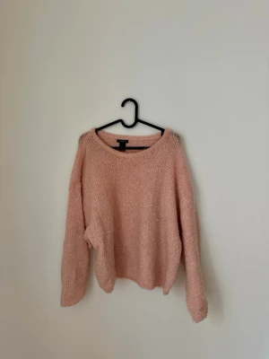 Ljusrosa stickad tröja Lindex - Mysig ljusrosa stickad tröja från Lindex med avslappnad passform. Tröjan har långa ärmar och är gjord i ett fluffigt, mjukt material som känns skönt mot huden. 