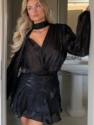 Populär klänning från Gina Tricot. - Populär & slutsåld klänning från Gina Tricot, ”mini frill dress”, draperad klänning med scarf & v-rigning, kort längd, volanger, ballongärmar. 🩰nypris 599! Helt ny med prislapp kvar.