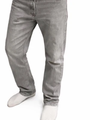 Jack & Jones Grå raka jeans i bomull - Säljer ett par grå jeans med rak passform och klassisk femficksdesign. Jeansen har normal midja och är tillverkade i mjuk bomull. Perfekta för en avslappnad och stilren look.