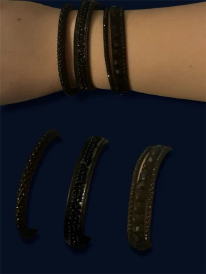 Svarta armband med glittrande stenar - Säljer tre snygga svarta armband med glittrande stenar och struktur. Armbanden har en halvcirkelformad design och är perfekta för att ge din outfit lite extra edge. Materialets är läder på två och metall på de första!