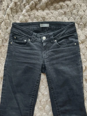 Svarta Bootcut Jeans - Gina Tricot - Svarta bootcut jeans från Gina Tricot med klassisk femficks modell och silver detaljer. Jeansen är mellan lowwaist och midwaist, och är storlek 36/S. Skulle passa XS bra också. Fint skick, små slitningar som man ej tänker på.