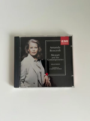 CD - Mozart and his contemporaries - Amanda Roocroft - CD med Amanda Roocroft som framför verk av Mozart och hans samtida kompositörer. Medverkar gör även Neville Marriner och Academy of St Martin-in-the-Fields.  ”Mozart and his Contemporaries". Dirigent: Neville Marriner. Orkester: Academy of St Martin-in-the-Fields.  Något alla som älskar klassisk musik borde ha i cd-hyllan. Fint skick!!