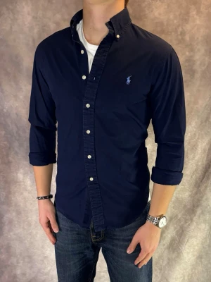 Marinblå Ralph Lauren Skjorta - Stl S, Slim fit - RIKTIGT FET RL SKJORTA I FÄRGEN MARINBLÅ 👔Mycket bra skick: 9,5/10, utan defekter! | Stl: S, Modellen är 175cm och väger ca 77kg,  | Hör av dig vid frågor // Galgen 🫡